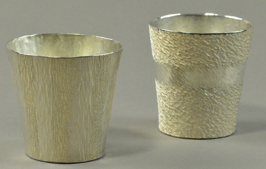 HIROSHI SUZUKI (born 1961); two hallmarked 999 grade fine silver beakers, hammer raised banded