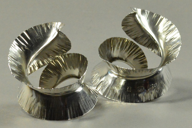 RAUNI HIGSON (born 1970); a pair of hallmarked silver napkin rings of spiral feather form, London