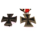 Two German medals, a WWI Iron Cross First Class and a WWII Iron Cross Second Class.