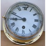 A brass cased ship's clock with white enamel dial set with Roman numerals inscribed “Made in