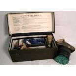 A military issue A.R.P. first aid kit and a WWII gas mask (2).