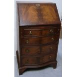 A 20th century walnut bow fronted fall front bureau of small proportions with brass escutcheon and