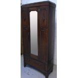 An Edwardian oak Arts and Crafts style single wardrobe on bracket feet.