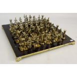 A contemporary chessboard with two complete sets of metal figures depicting Romans,