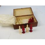 A late 19th century turned and stained bone chess set, height of king 9cm, contained within a