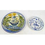 A 19th century Dutch Delft charger hand painted with a ship within a foliate and floral border,