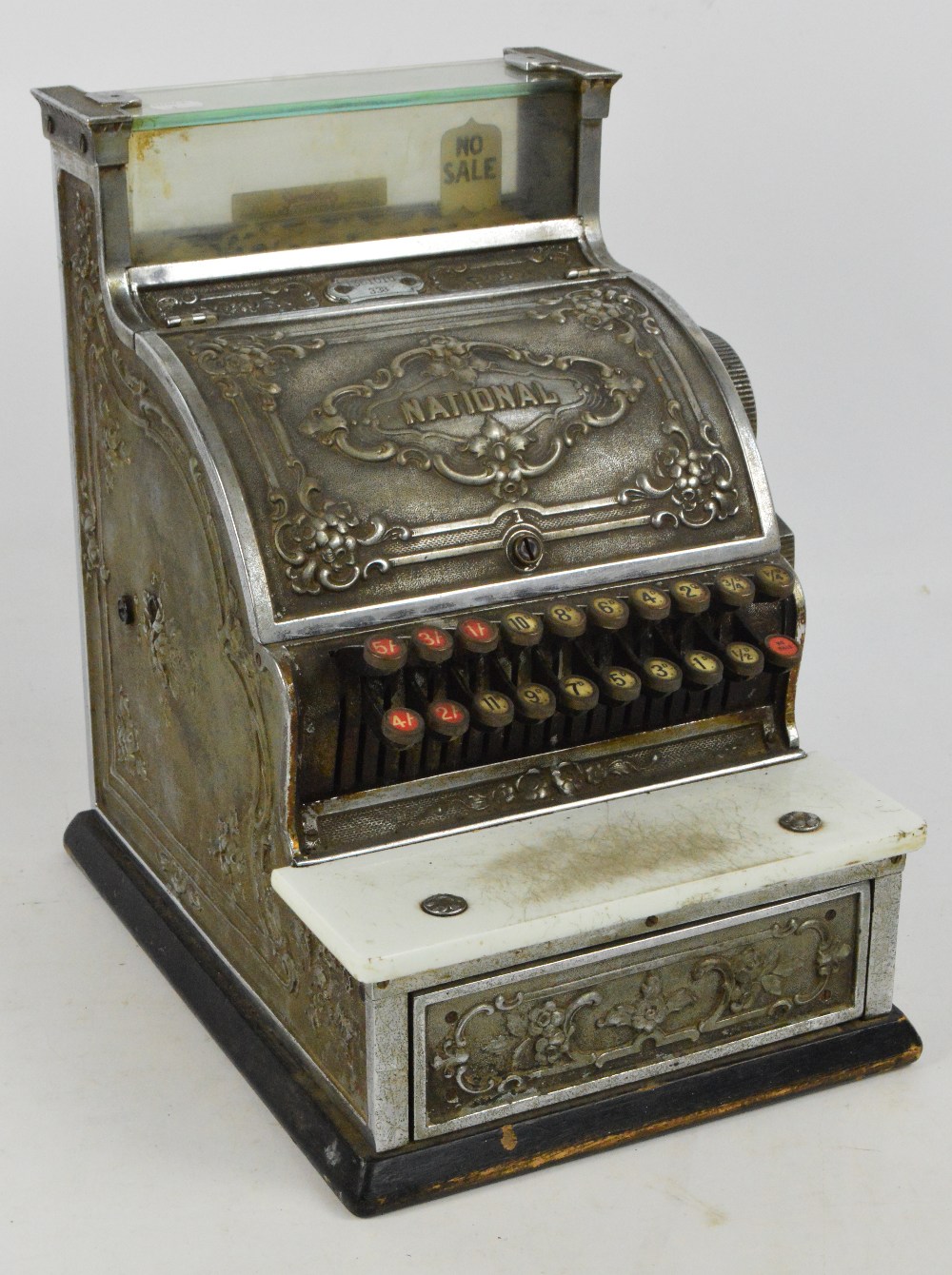 An early 20th century National Cash Register with glazed viewing section, floral embossed main panel