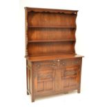 A reproduction oak dresser with boarded plate rack.