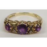 A 9ct gold Victorian style dress ring with three amethyst coloured stones in high decorative