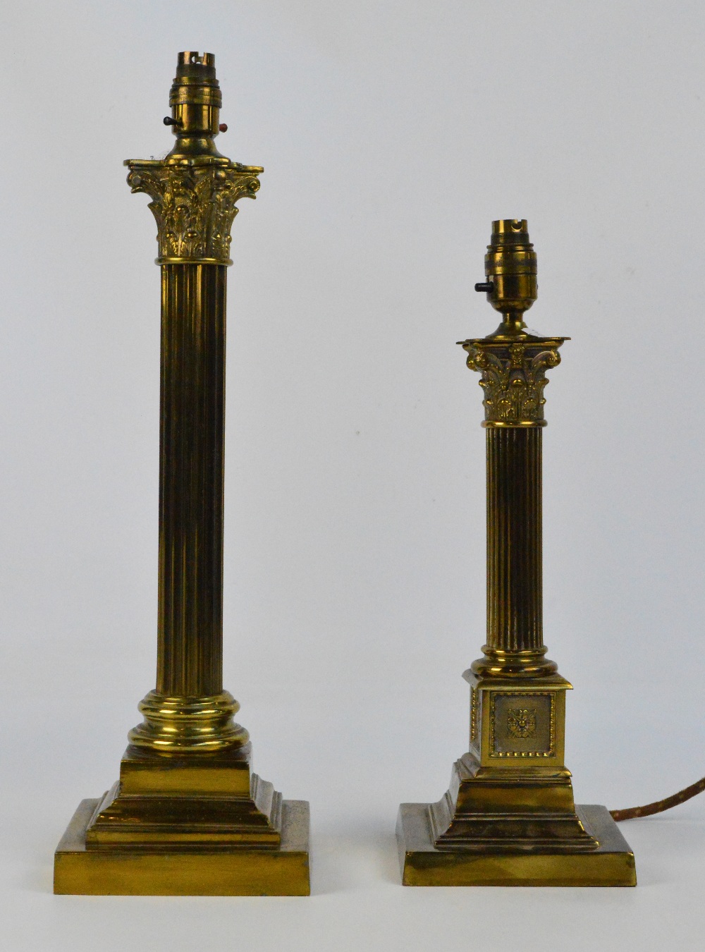 Two brass Corinthian column table lamps, both on stepped square section bases, height 55cm and 45cm.