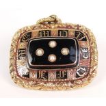 An early Victorian yellow metal and enamel mourning brooch of rounded rectangular form set with