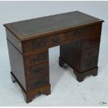 A reproduction pedestal desk with leather inset top and two frieze drawers above two sets of three
