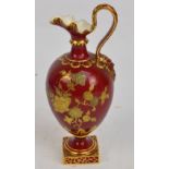 A Derby gilt heightened crimson ground ewer with high loop handle to embossed mask, floral