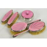 A George VI hallmarked silver mounted and pink guilloche enamel backed five piece dressing table set