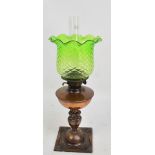 An Art Nouveau copper oil lamp with green glass shade, rounded reservoir, and embossed main