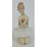 A Lladro figure of seated ballerina holding a bunch of roses, height 26cm. CONDITION REPORT: A