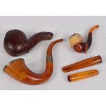 Two cased amber coloured cigar holders,