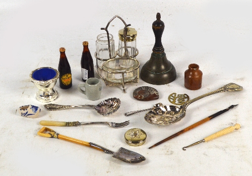A collection of plated items including a three piece cruet on stand, a small ivory handled spade,