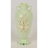 A Mintons pale green floral encrusted twin handled vase, profusely decorated with delicate floral