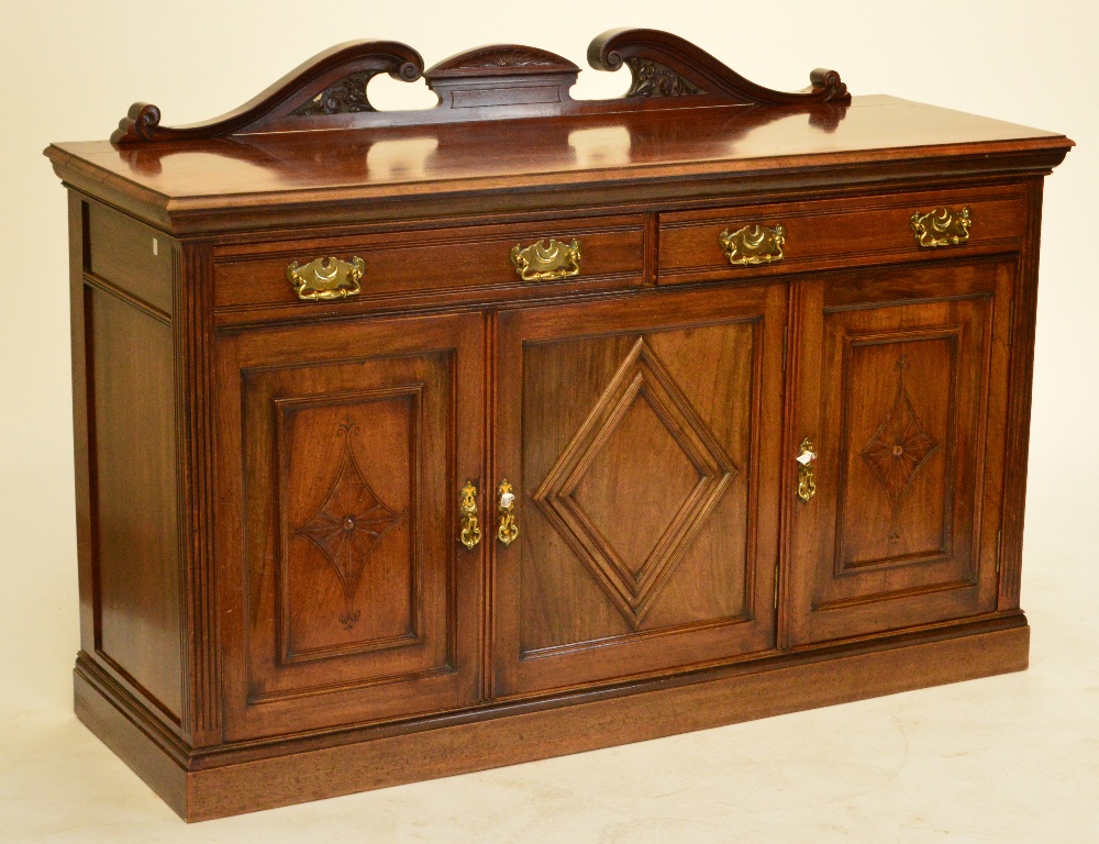 A late Victorian walnut sideboard with two frieze drawers and two cupboard doors to plinth base,