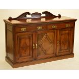 A late Victorian walnut sideboard with two frieze drawers and two cupboard doors to plinth base,