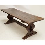 An oak plank top refectory table raised on shaped end supports united by a stretcher, length 239cm.
