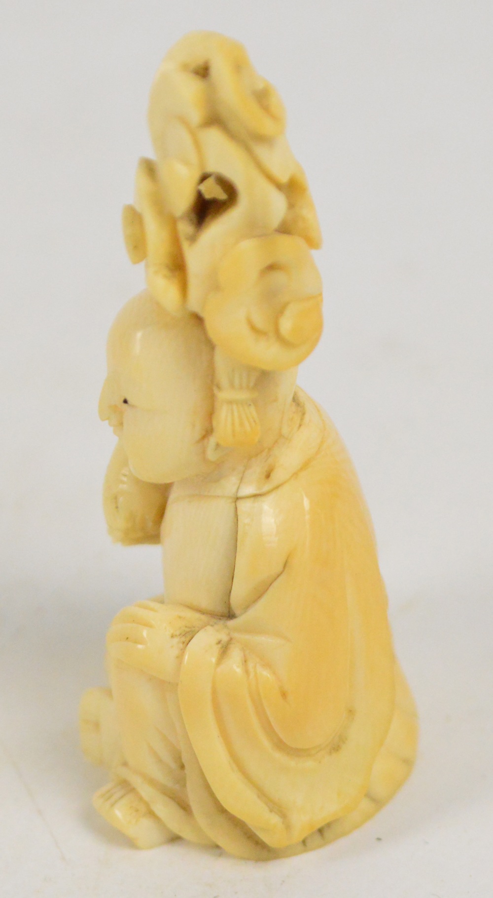 A 19th century Japanese carved ivory okimono depicting a seated man holding a blossoming nut, - Image 4 of 5