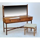 A 1960s teak dressing table with three frieze drawers and turned legs united by shaped stretcher,