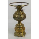 A Victorian brass oil lamp with pierced decorative reservoir,