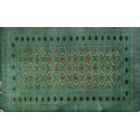 A Bokhara green ground rug.