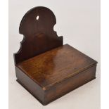 A late 19th century shallow oak salt box with shaped back support with hanging hole, width 22cm,