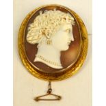 A yellow metal mounted oval cameo brooch depicting the head of a young woman, with applied