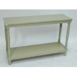 A painted rectangular two tier console table raised on turned supports to peg feet, width 130cm.