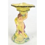 An early 19th century Staffordshire figural vase, modelled as a cherubic figure holding aloft a