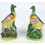 A pair of Victorian Staffordshire figures of birds standing on rocky mounts, height 26cm (af).