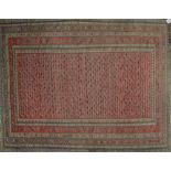 A hand knotted woollen Hamadan rug decorated with geometric medallions.