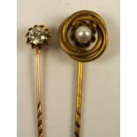 A yellow metal stick pin set with a single circular diamond weighing approximately 0.