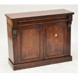 An early Victorian mahogany two door side cabinet with shaped frieze drawer, two arched cupboard