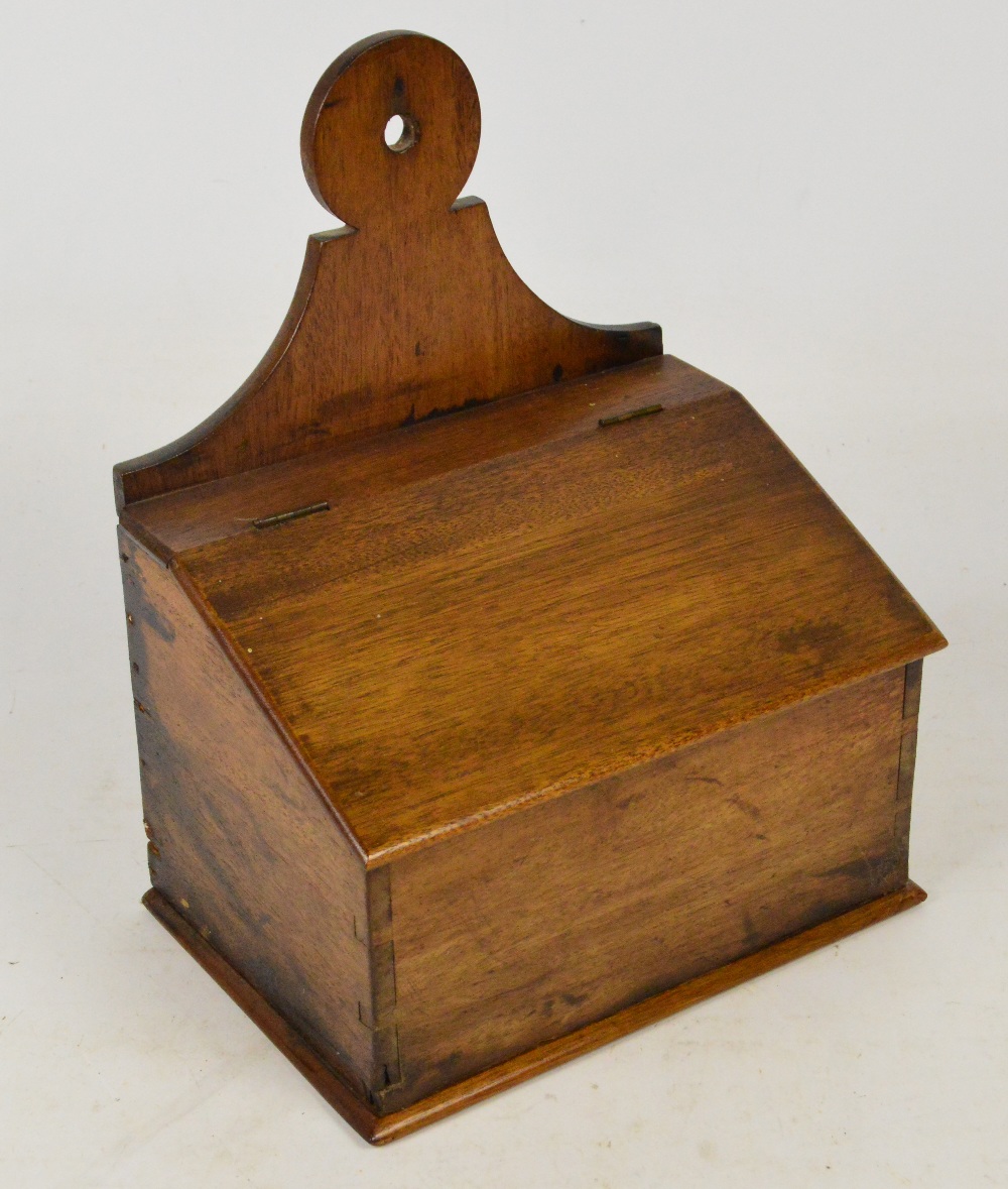 A 19th century mahogany salt box with raised back plate and hinged sloping lid, width 24cm.