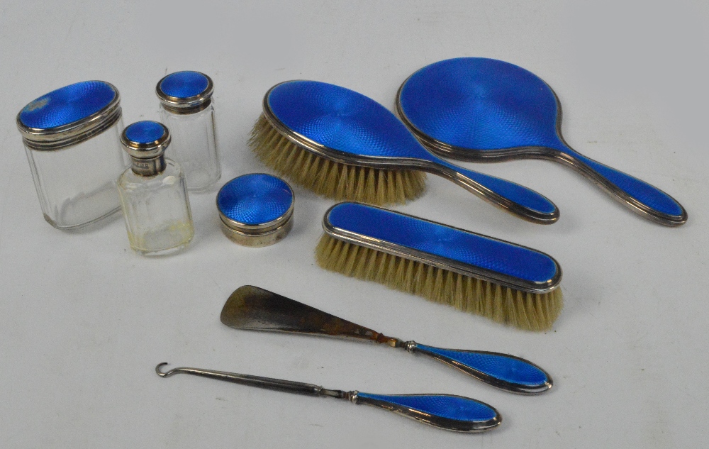 A George V hallmarked silver backed and blue guilloche enamel decorated nine piece dressing table