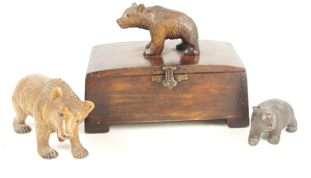 A carved figure of a Black Forest bear with glass inset eyes and mouth open, length 12cm,