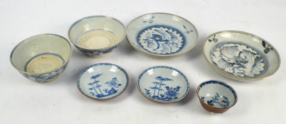 A mid 18th century Nanking cargo blue and white tea cup and two saucers with cafe au lait glaze to