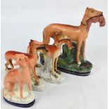 A pair of late 19th century Staffordshire figures of greyhounds carrying rabbits, height 19cm, a