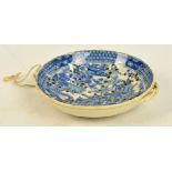 A mid 19th century blue and white twin handled egg separator, transfer decorated with Oriental