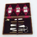 A red leather cased sewing set with mother of pearl handled implements,