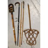 A vintage bamboo carpet beater, an ebonised cane with silver collar,