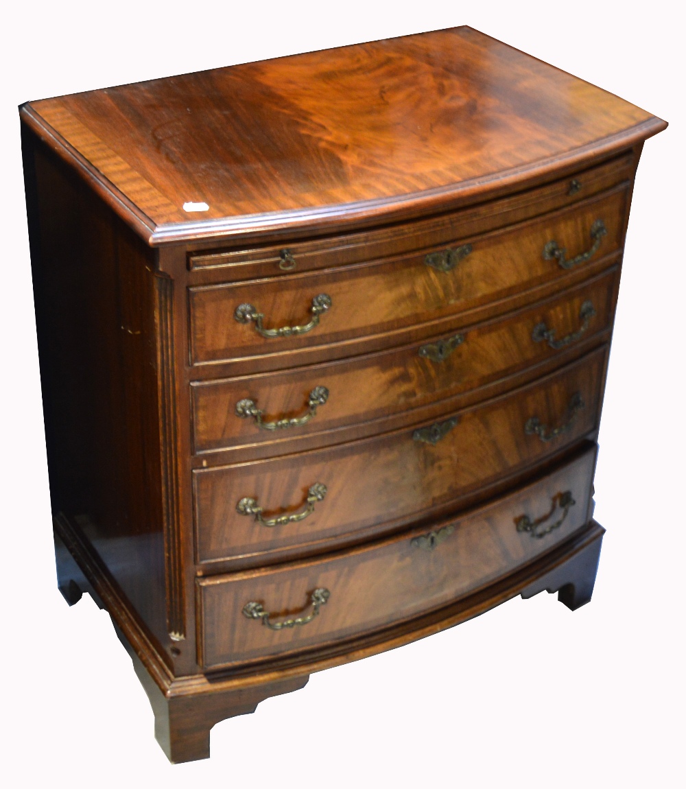 A reproduction mahogany bow front bureau four drawer chest of drawers with pull out writing top and