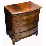 A reproduction mahogany bow front bureau four drawer chest of drawers with pull out writing top and