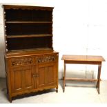 An oak dresser of small proportions, two carved short drawers above two cupboard sections,