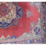 A red ground Turkish rug, approx 330 x 210cm.